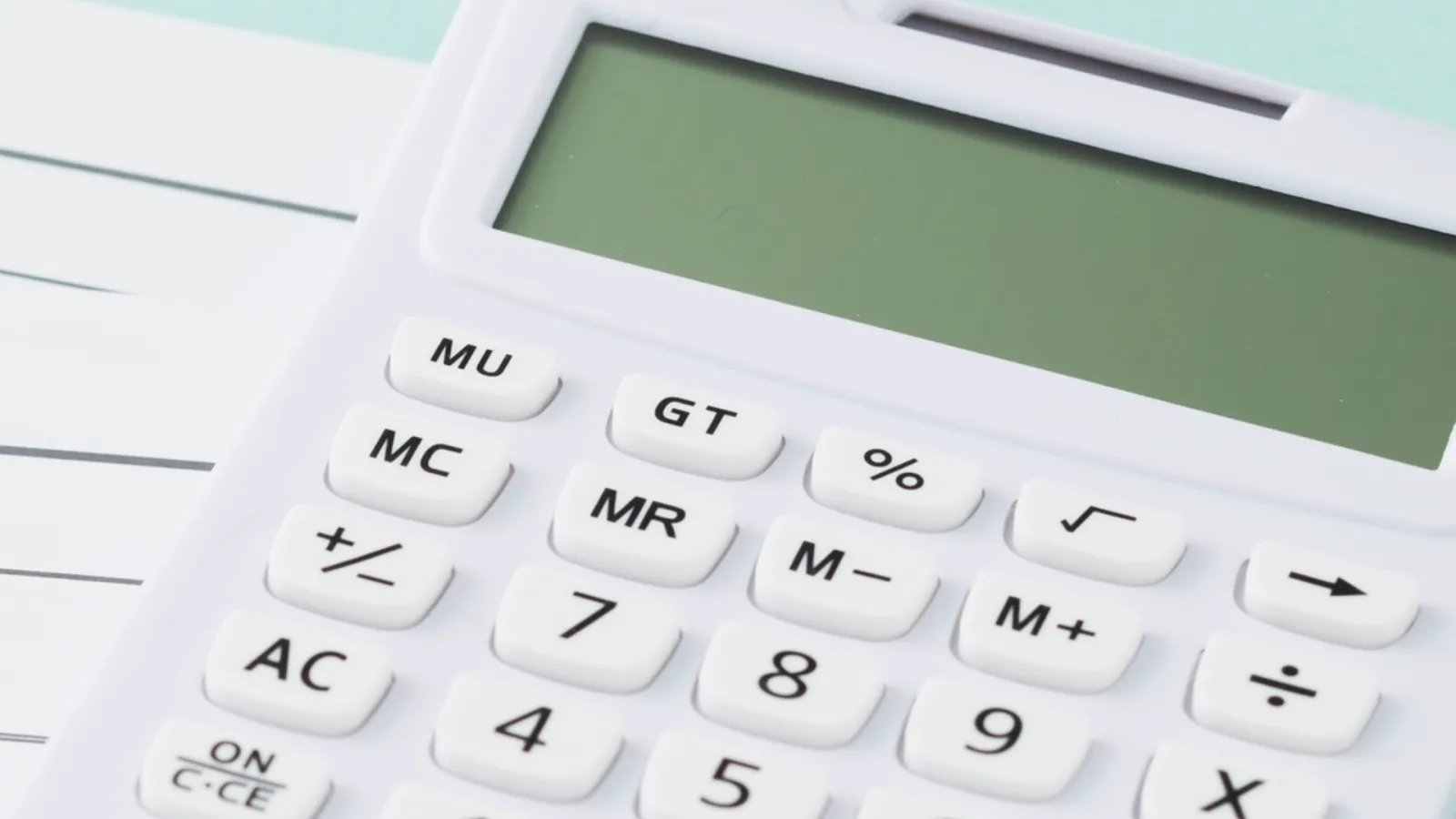 Calculatrice blanche posée sur un document, pour estimer le prix d'une recherche de fuite